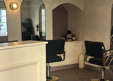 Chic interior of Hair By B at Amica Hair & Beauty, Thirsk, England, GB. Black chairs and modern mirrors.
