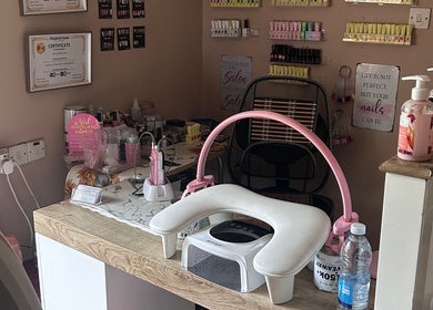 Nail station at Giggles and Gloss in Alderholt, England, GB with a focus on tools and colorful polishes.