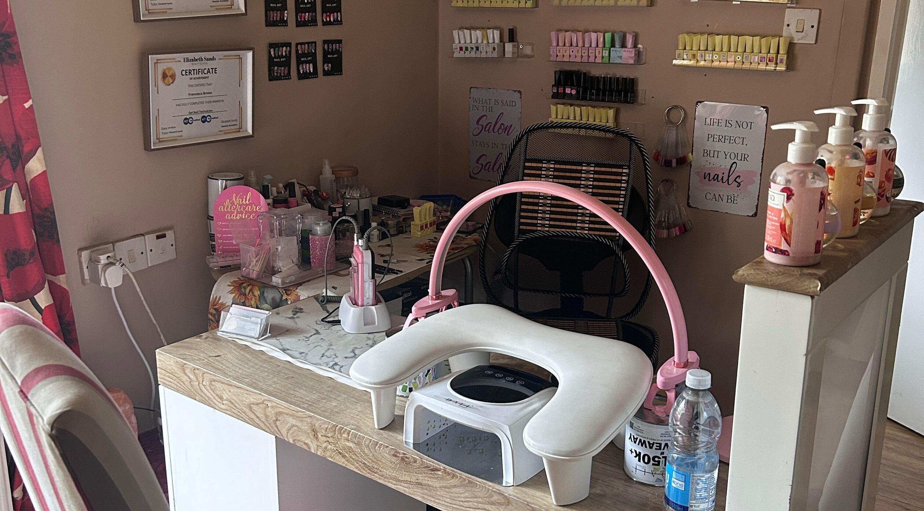 Nail station at Giggles and Gloss in Alderholt, England, GB with a focus on tools and colorful polishes.