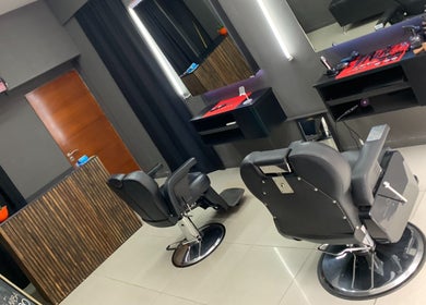 Interior moderno del Tata Barber Suite en Rosario, Santa Fe, AR, con sillas de peluquería y decoración elegante.