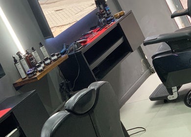 Interior moderno de Tata Barber Suite en Rosario, Santa Fe, AR con sillón y productos de belleza.
