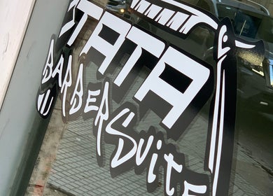 Ventana con logo de Tata Barber Suite en Rosario, Santa Fe, AR.