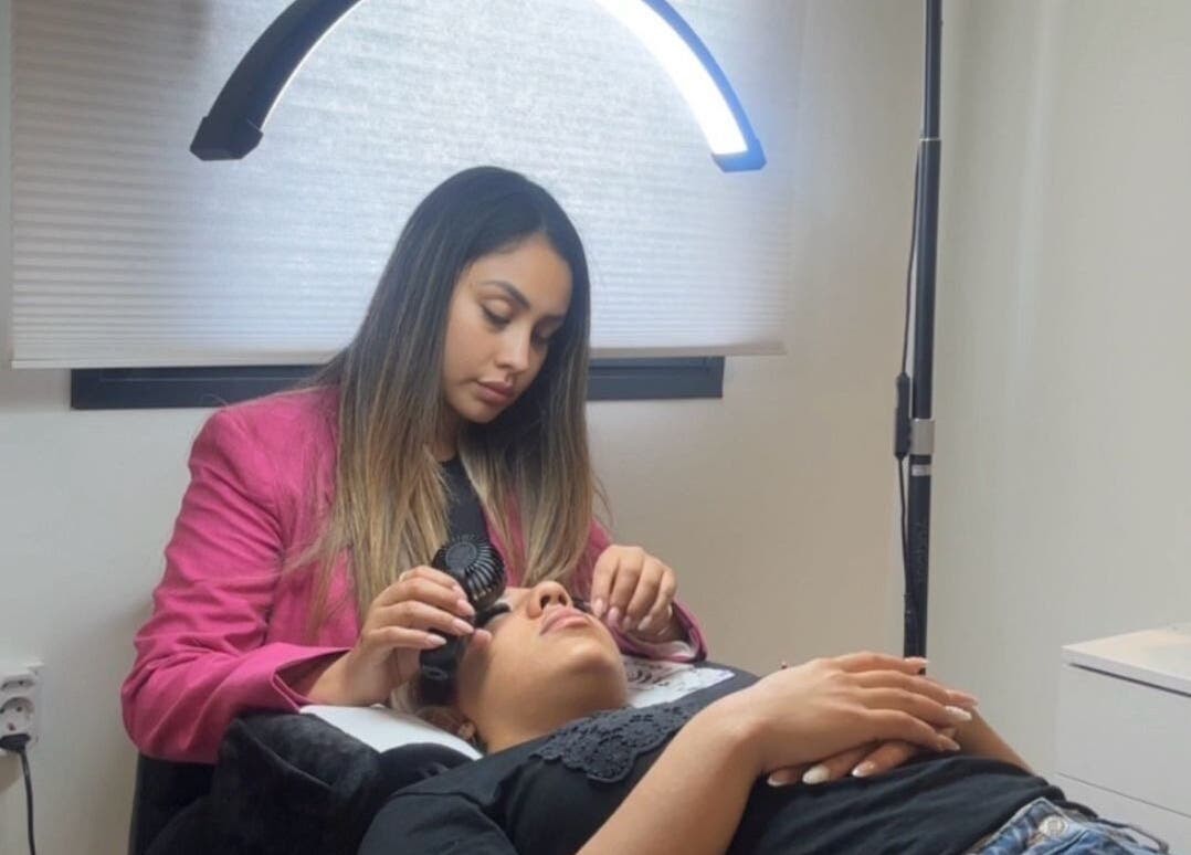 Esteticista aplica pestañas en Cottonlashes, Barcelona, Catalunya, ES, resaltando servicio profesional.