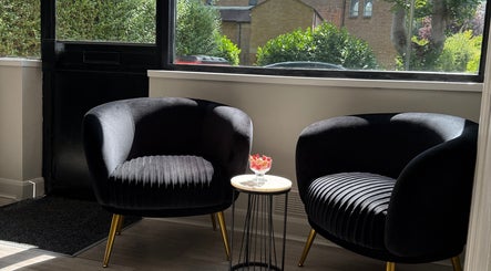 Pair of elegant chairs at Gemini Hair, Birmingham, England, GB, capturing serene natural light and cozy ambiance.