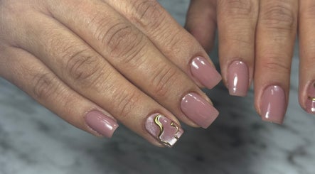 Diseño elegante de uñas en Minou’s Studio, Ambato, Tungurahua, EC, resaltando con tonos rosados y detalles dorados.