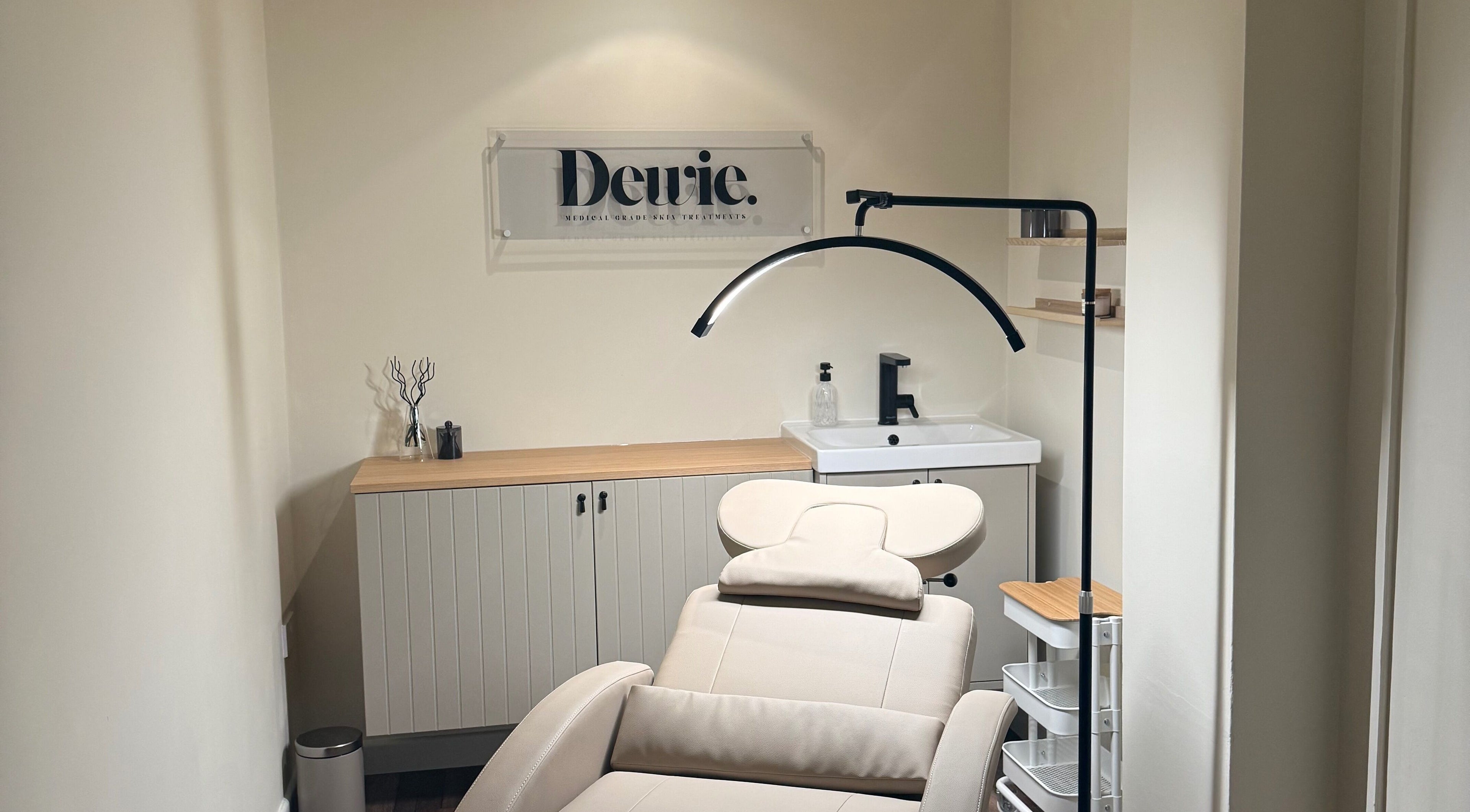Calm treatment room at Dewie Skin in Nantwich, England, GB with a comfortable chair and modern decor.