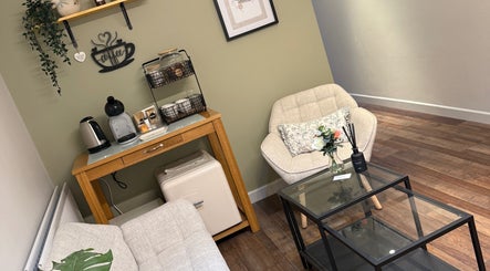 Relaxing lounge at Dewie Skin in Nantwich, England, GB with cozy chairs and coffee setup.
