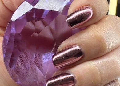 Elegant chrome nails holding a purple gem at Shine Nails, Buffalo Grove, Illinois, US.