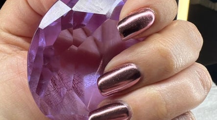 Elegant chrome nails holding a purple gem at Shine Nails, Buffalo Grove, Illinois, US.