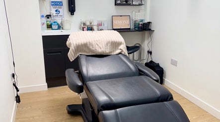 Relaxing treatment room at Simone Services, Edinburgh, Scotland, GB, featuring a plush black reclining chair.