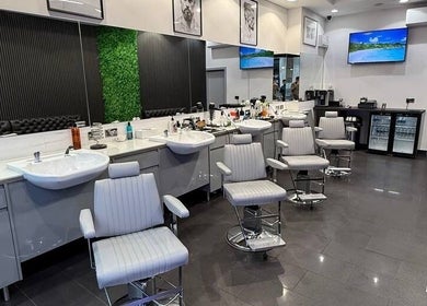 Spacious interior of Db Barbers Tooting Bec, London, England, GB with modern barber chairs and stylish decor.