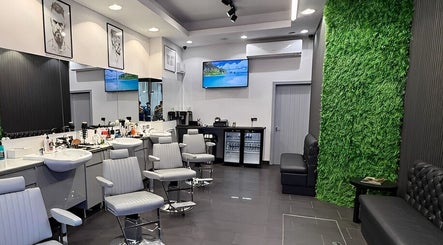 Modern interior of Db Barbers Tooting Bec, London, England, GB with sleek chairs and green accent wall.