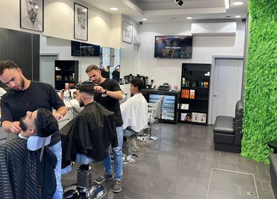 Stylish interior of Db Barbers Tooting Bec, London, England, GB, featuring skilled barbers at work.