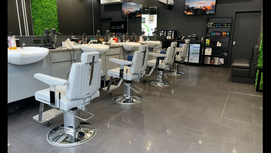 Modern barber chairs at Db Barbers Tooting Bec, London, England, GB, with sleek interior design.