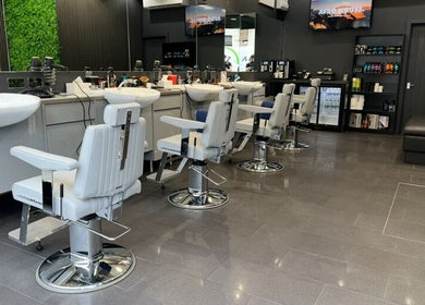 Modern barber chairs at Db Barbers Tooting Bec, London, England, GB, with sleek interior design.