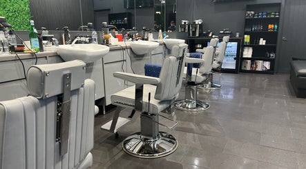 Modern barbershop interior at Db Barbers Tooting Bec, London, England, GB, featuring stylish barber chairs.