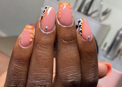 Vibrant nail art at Clawed By Grace in Freeport, Freeport, BS, featuring orange and leopard print designs.