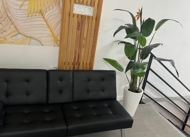 Sleek black sofa and plant decor at Aesthetics by Briella, Montego Bay, St. James Parish, JM.