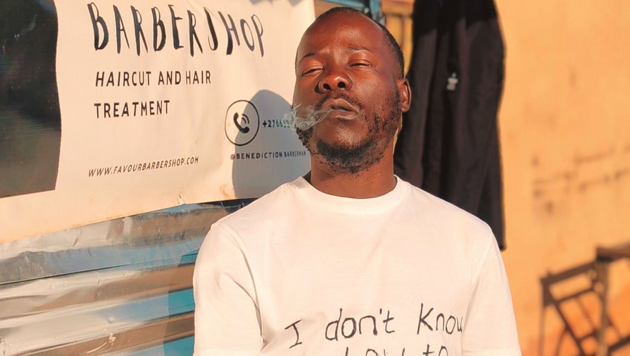 Person outside Favour Barbershop, Thembisa, Gauteng, ZA enjoying a moment, highlighting barber services.