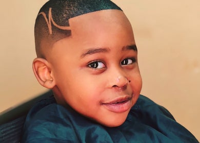 Child with a trendy haircut at Favour Barbershop in Thembisa, Gauteng, ZA, showcasing style and precision.
