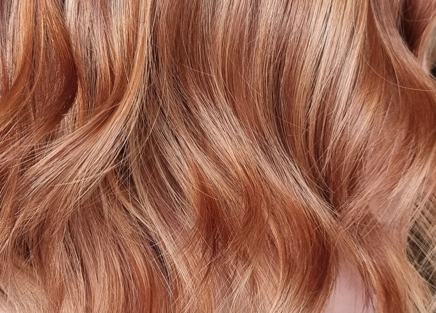 Rich copper hair waves styled at Brushed Salon, Penarth, Wales, GB for vibrant and luxurious hair shine.