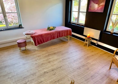 Salle de soins lumineuse à Bubble Connection, Waterloo, Région Wallonne, BE avec table de massage et décoration zen.