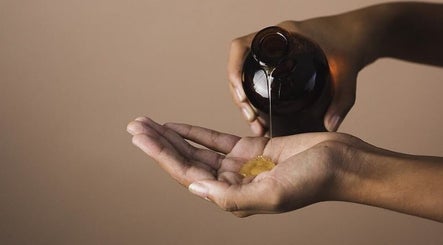 Close-up of oil being poured into a hand at Maison Iaso, London, GB, highlighting wellness and relaxation.
