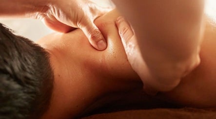Relaxing massage therapy at Maison Iaso, London, GB, showcasing skilled hands providing soothing back treatment.