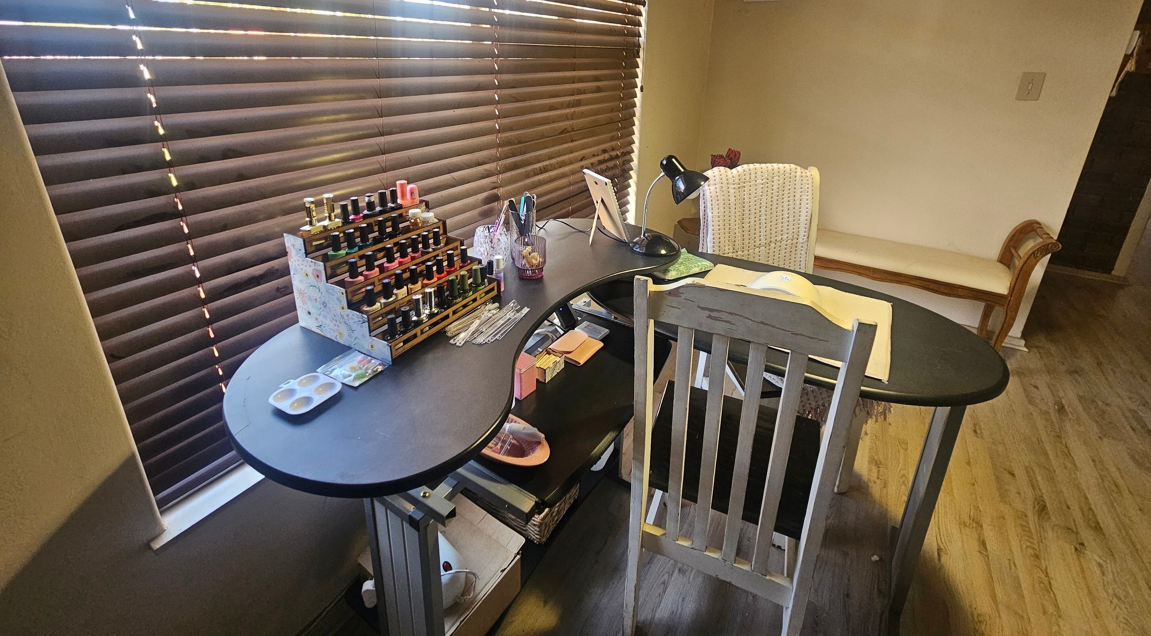 Nail station setup at Blom & Blink Nails, Bloemfontein, Free State, ZA with polish display and cozy chair.