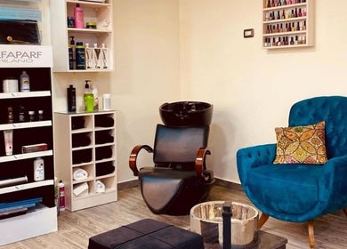 Cozy Nail.haven9 salon lounge in Amman, Amman Governorate, JO with chic blue chair and product display.