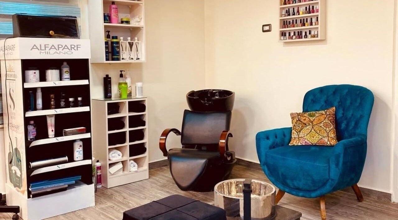 Cozy Nail.haven9 salon lounge in Amman, Amman Governorate, JO with chic blue chair and product display.