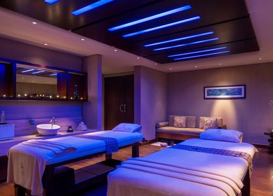 Relaxing spa room at Zayna Spa, Abu Dhabi with ambient lighting and massage tables.