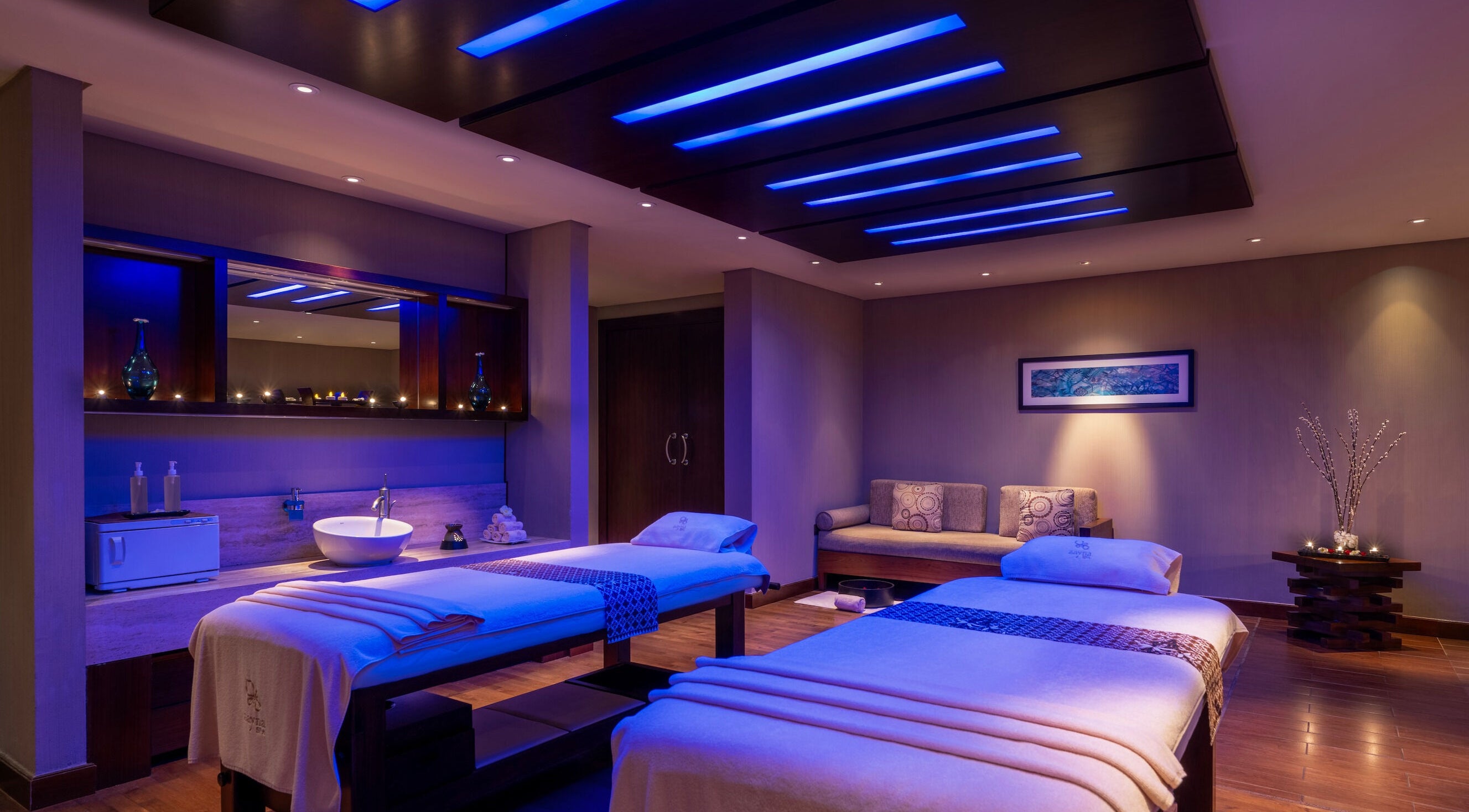 Relaxing spa room at Zayna Spa, Abu Dhabi with ambient lighting and massage tables.