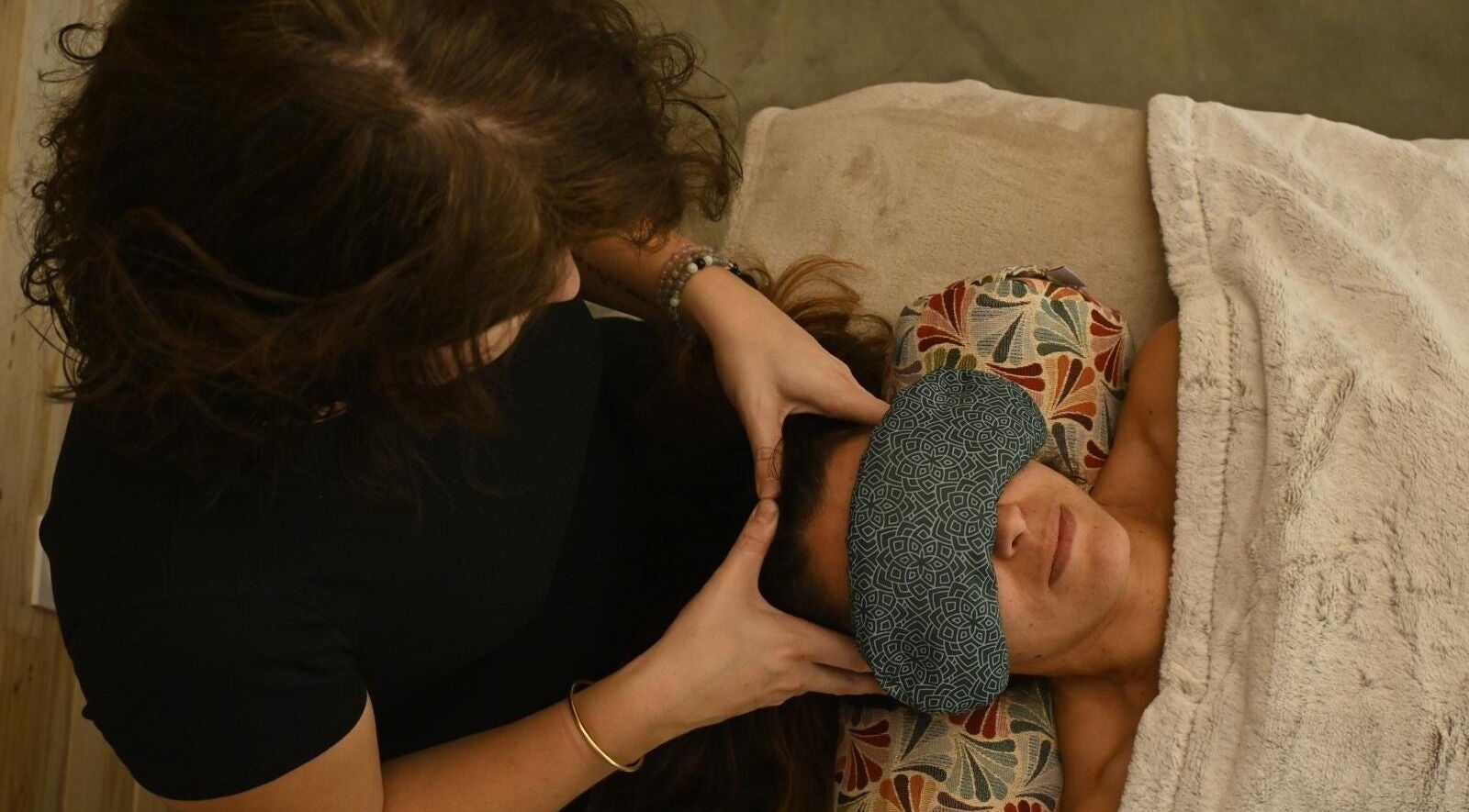 Massage de tête à L'atelier Prasama à Saint-paul-les-fonts, Occitanie, FR. Client détendu sous un plaid.