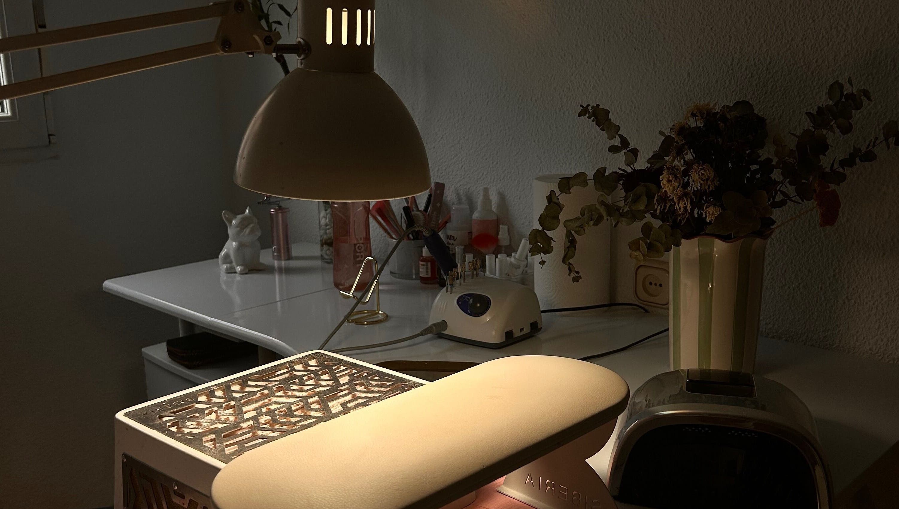 Mesa de trabajo en Venus Acrylic Nails, Granada, Andalucía, ES, con lámpara y herramientas de belleza.