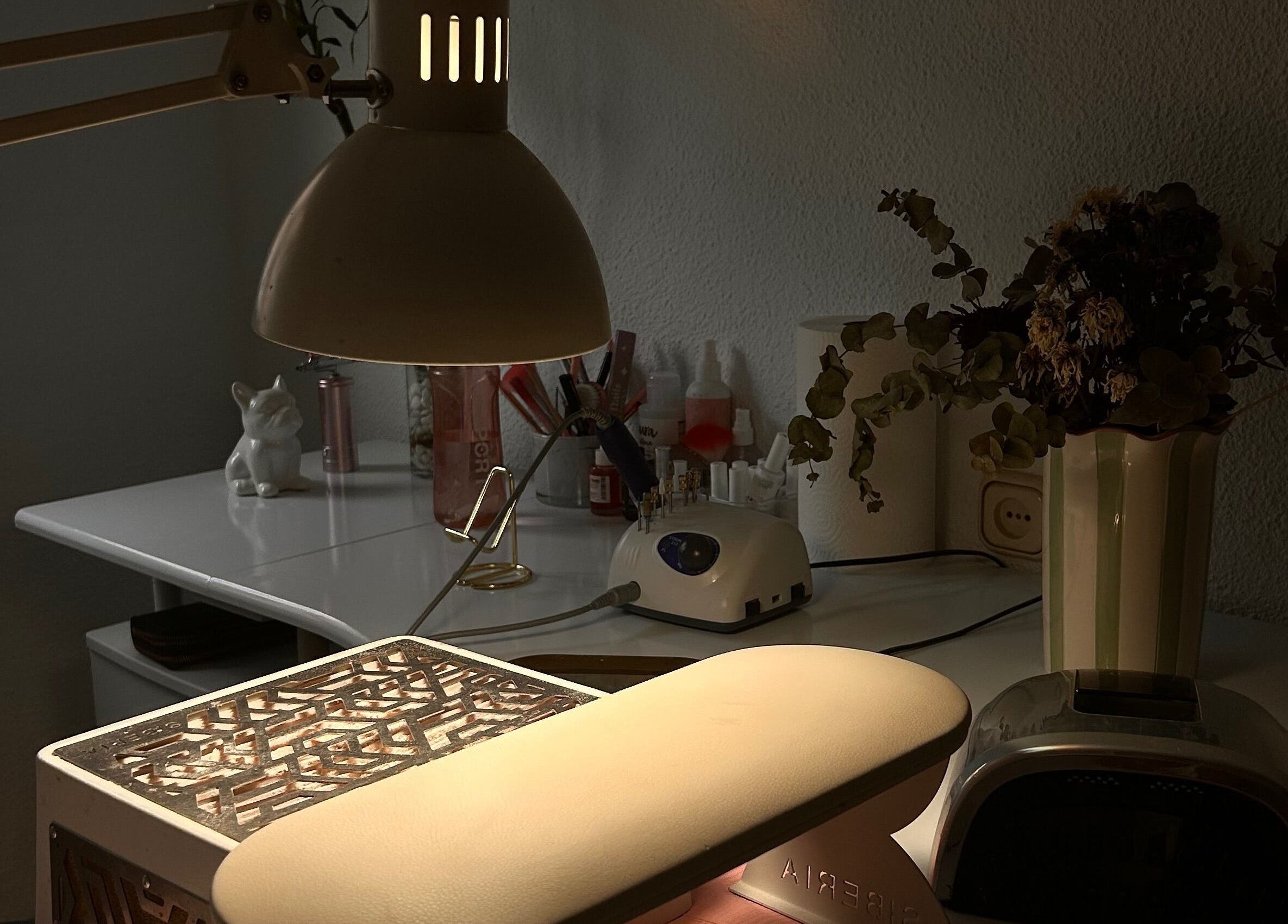 Mesa de trabajo en Venus Acrylic Nails, Granada, Andalucía, ES, con lámpara y herramientas de belleza.