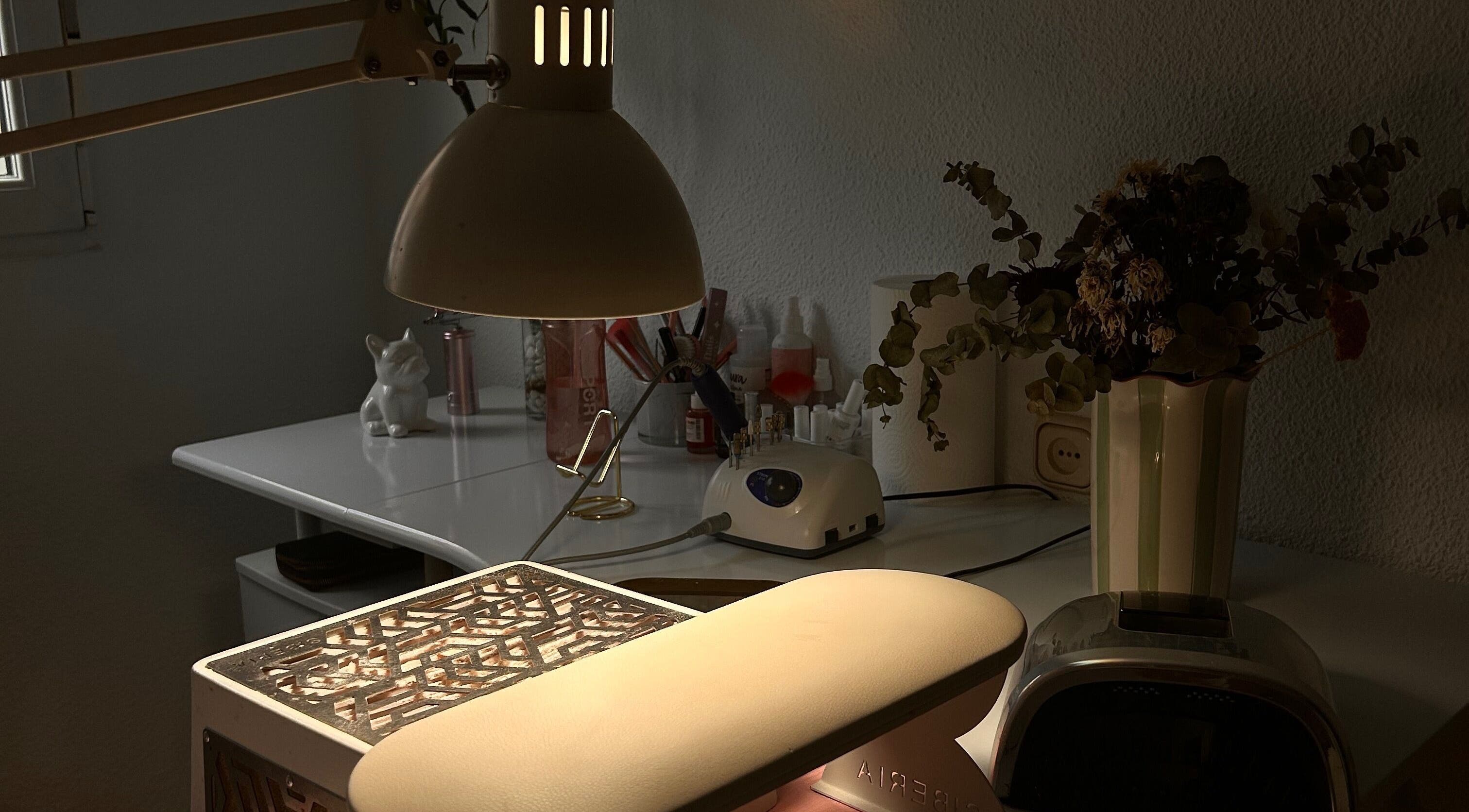 Mesa de trabajo en Venus Acrylic Nails, Granada, Andalucía, ES, con lámpara y herramientas de belleza.