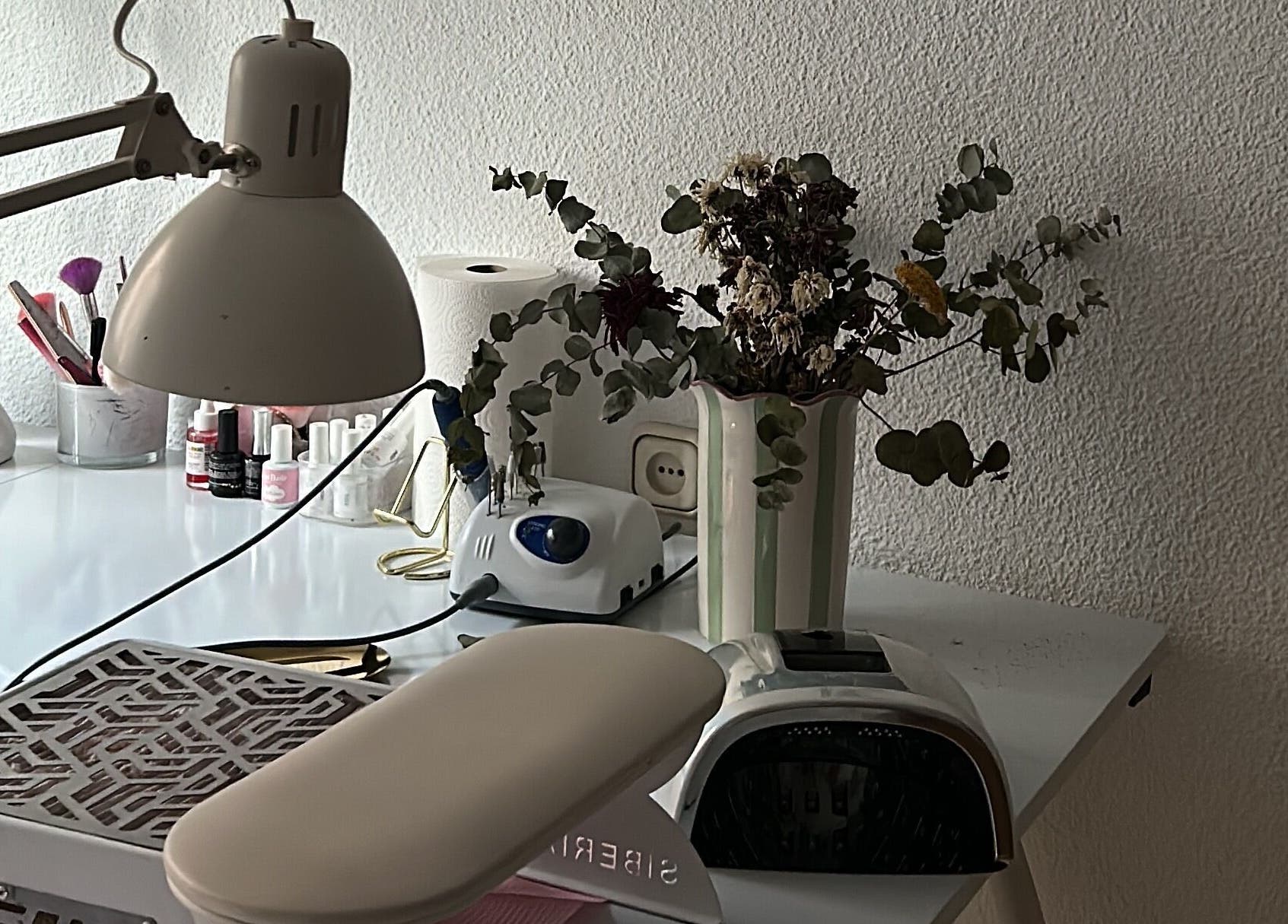 Mesa de manicura en Venus Acrylic Nails, Granada, Andalucía, ES. Detalles de lámpara y floreros.