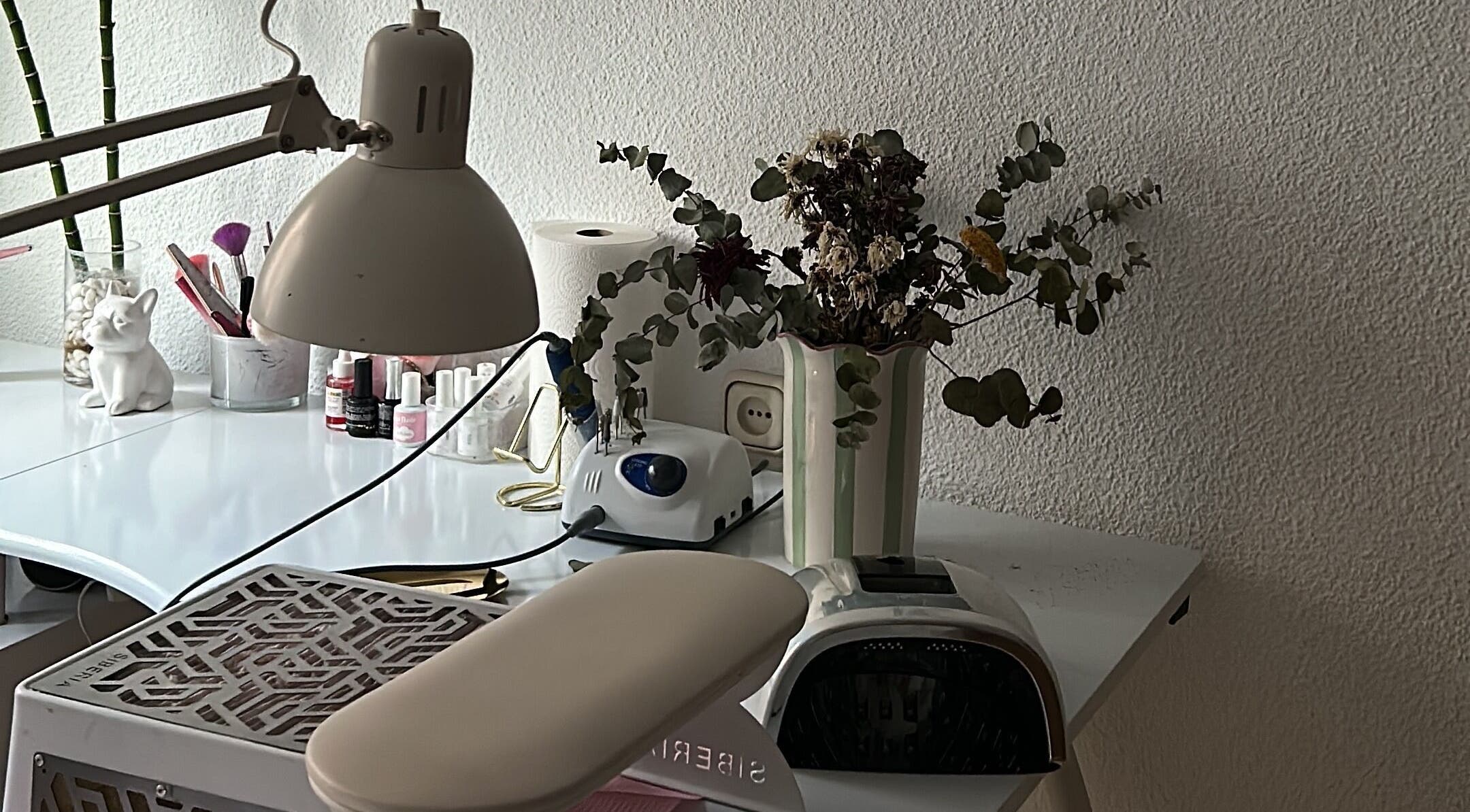 Mesa de manicura en Venus Acrylic Nails, Granada, Andalucía, ES. Detalles de lámpara y floreros.