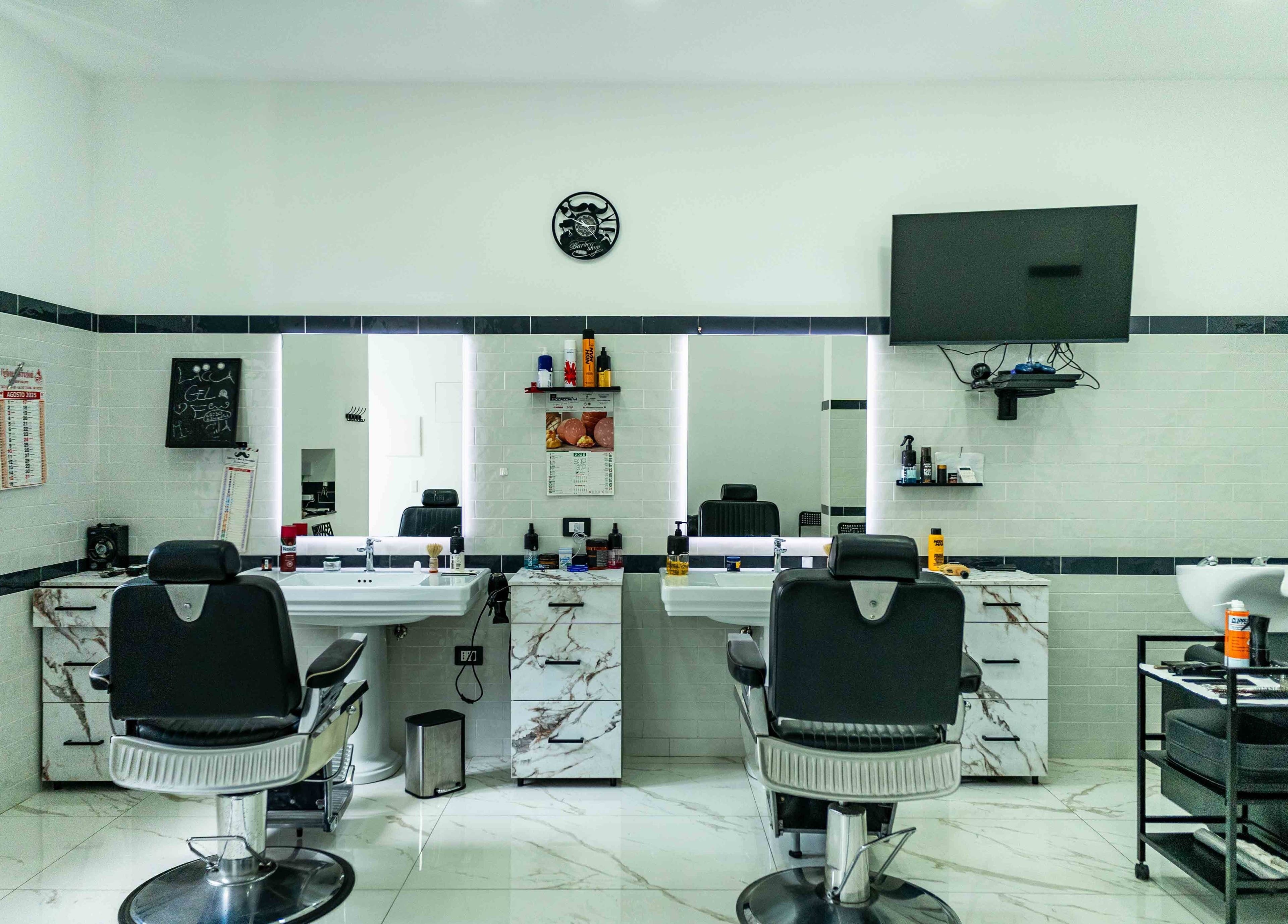 Interno elegante di Lacca Gel & Fantasia a Tocco Caudio, Campania, IT, con moderne sedie da barbiere.