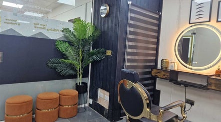 Elegant salon interior at Ray's House of Beauty, Hounslow, England, GB featuring stylish chairs and a lit mirror.