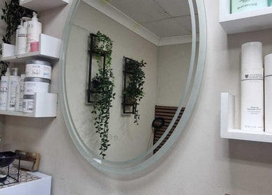 Elegant vanity with beauty products at Ray's House of Beauty, Hounslow, England, GB. Luxurious setting with greenery.