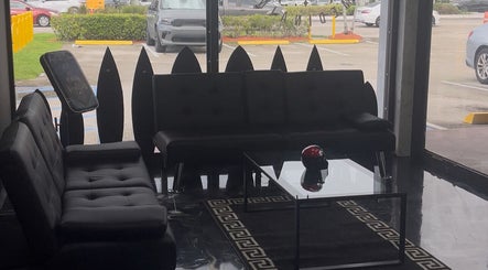 Elegant waiting area at Perfect Match Ink, Margate, Florida, US, with modern black couches and glass table.