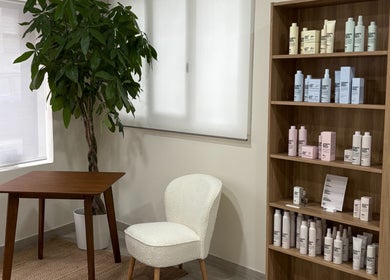 Rincón acogedor en Mi Studio, Pozuelo De Alarcón, con productos de belleza en estantería de madera.