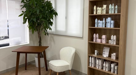 Espacio acogedor en Mi Studio, Pozuelo De Alarcón, con estantería de productos de belleza y planta decorativa.