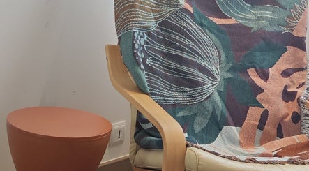 Fauteuil confortable avec couverture colorée chez Body & Flow, Annecy, Auvergne-rhône-alpes, FR.