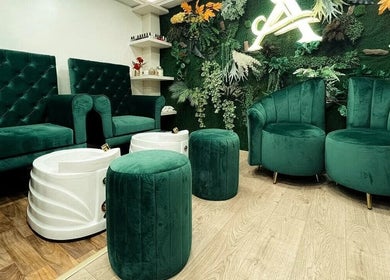 Elegant seating area at Salón de Belleza Panama, Panamá, Provincia De Panamá, PA with green velvet chairs and foliage.