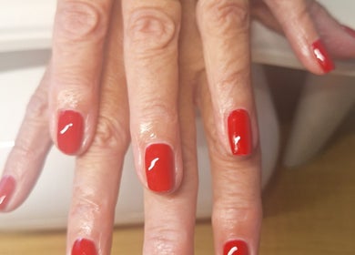Polished and Pretty nails with vibrant red polish in Crynant, Wales, GB.