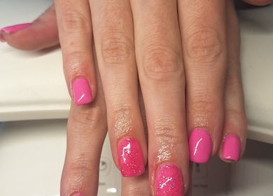 Vibrant pink glitter nails at Polished and Pretty, Crynant, Wales, GB, showcasing expert manicure services.