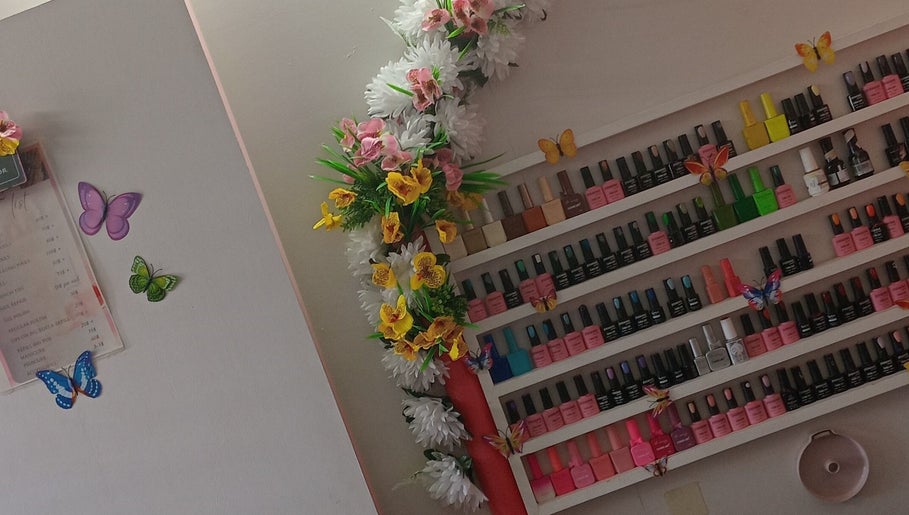 Vibrant nail polish display at Luv Ur Nails, Roseau, Saint George Parish, DM, with floral decor.